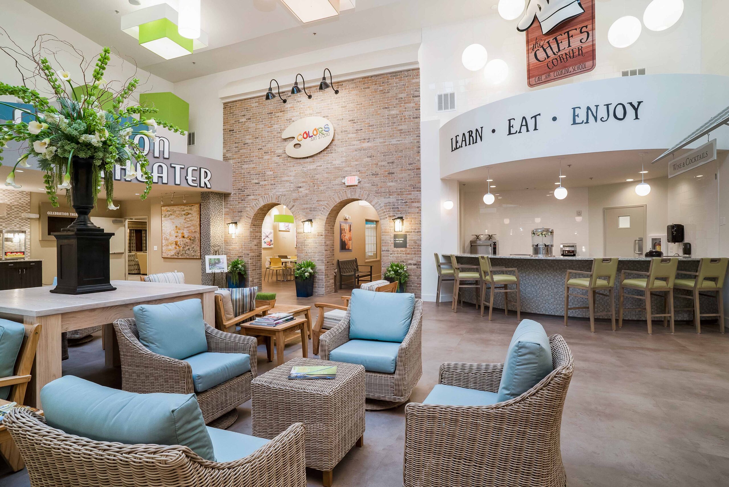 CelebrationVillageLg-60 - Celebration Village Forsyth A photo of the indoor sitting room with the Chef's Corner bar, Colors arts studio, and a movie theater at Celebration Village Forsyth, a senior living community near Alpharetta, GA.