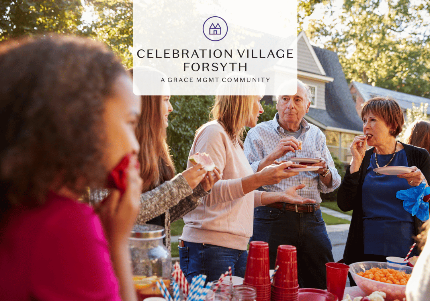 Group of adults enjoying an outdoor gathering with snacks and drinks at a community celebration, banner overlay reads Celebration Village Forsyth.